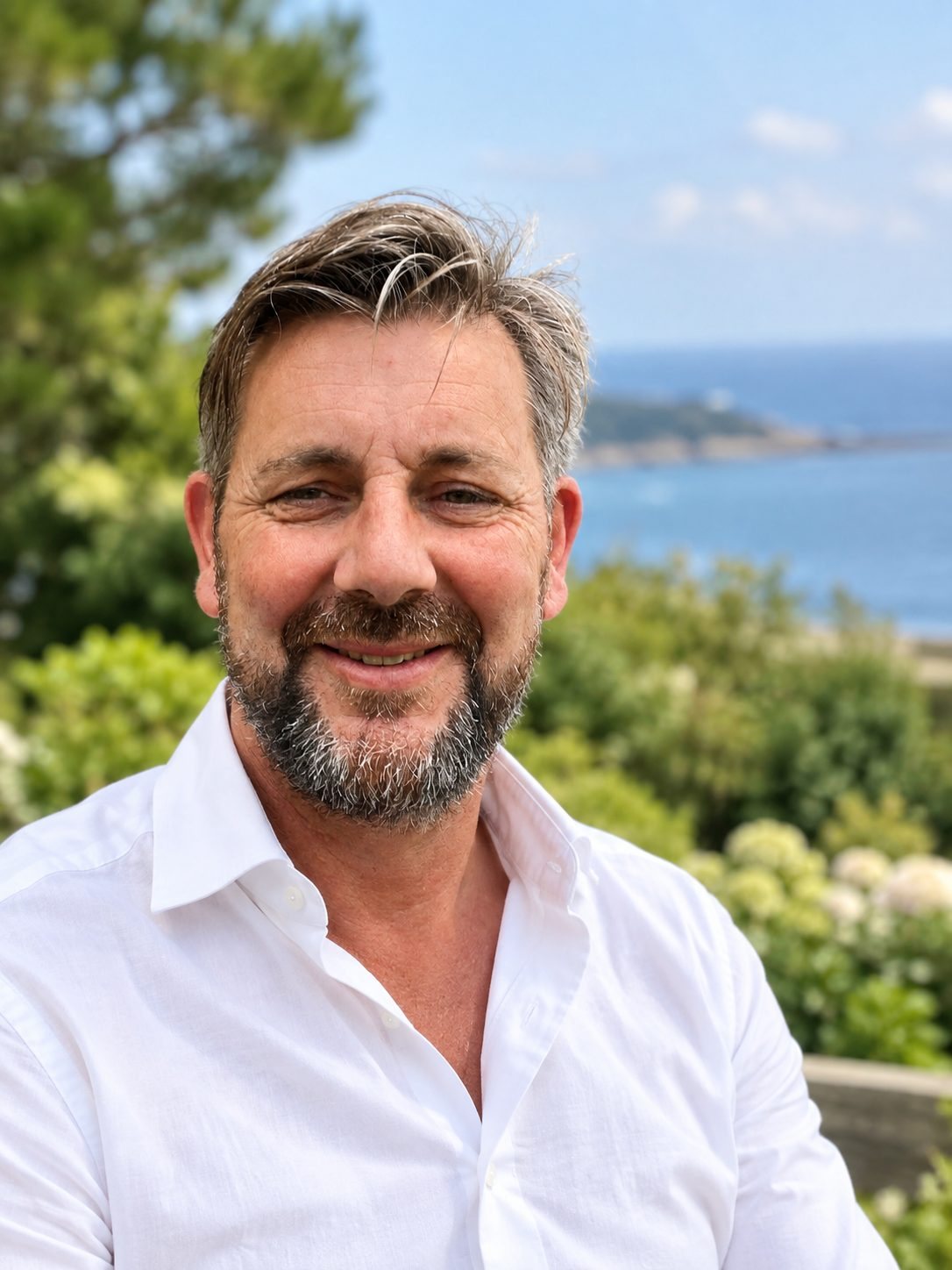 Christophe Lebrun, fondateur de Monsieur Georges, en chemise blanche devant la mer